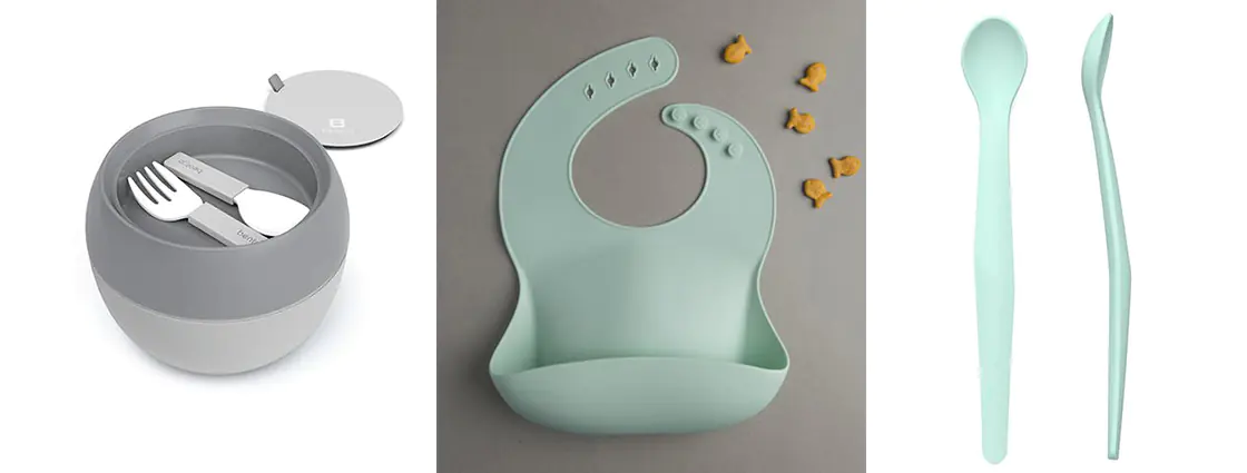 A grey Bentgo Insulated bowl on the left, a mint-colored silicone bib in the middle, and two mint silicone spoons on the right side