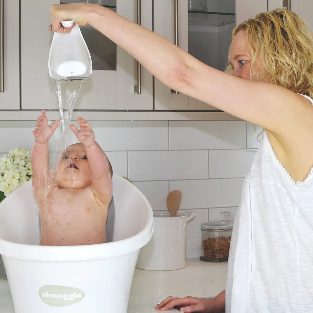 Parent gently rinsing a baby at bath time