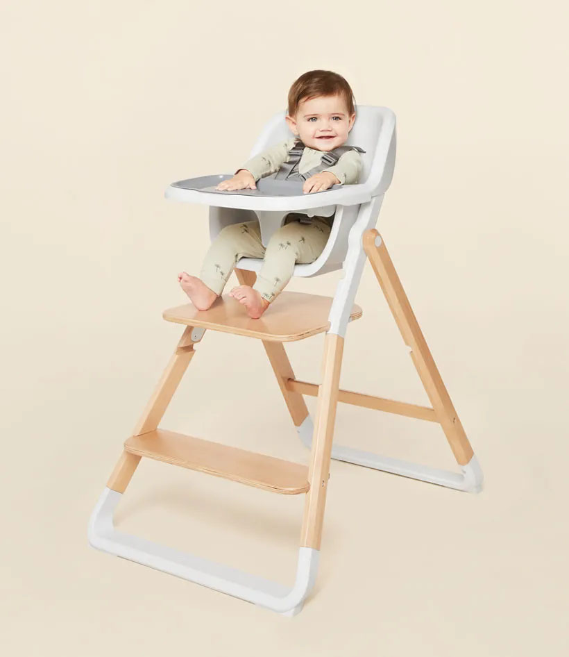 Baby seated in a wooden high chair