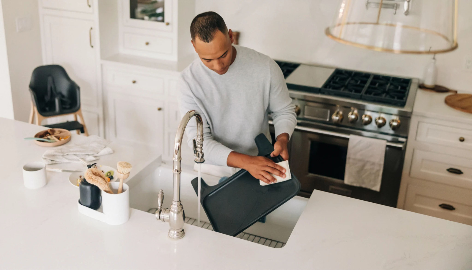 Parent cleaning a high chair tray